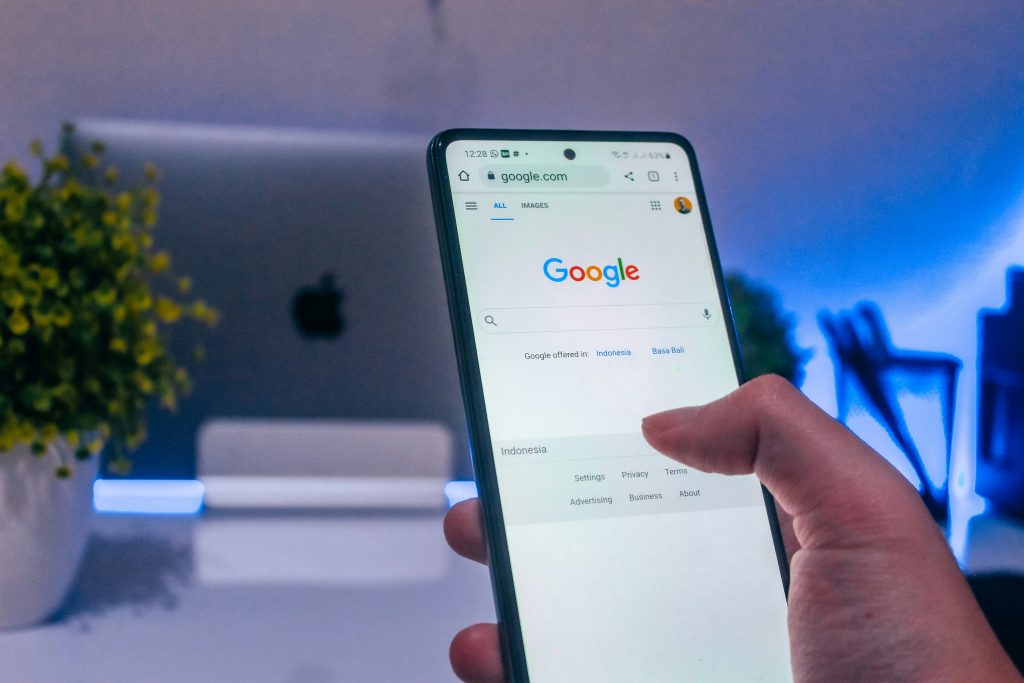 a hand holding a cell phone google on it