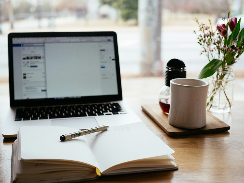 a laptop and a cup on a table